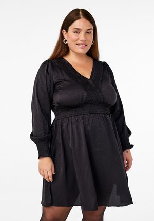 Abito nero realizzato in tessuto leggero, con scollatura a V, vita smock e maniche lunghe a sbuffo con polsini smock.