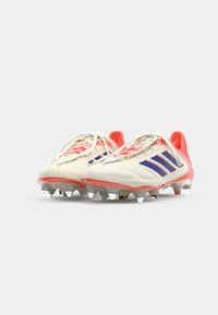 Schoenen met een romige witte body en roze accenten, voorzien van blauwe strepen. Ontworpen met een textuur oppervlak en doorzichtige noppenzolen.