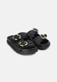 Infradito neri con cinturini testurizzati, dettagli in hardware dorato, suola piatta e design open-toe.