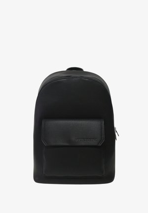 Zaino nero in finta pelle testurizzata, con forma arrotondata, tasca frontale e accento con marchio. Chiusura con zip nella parte superiore.