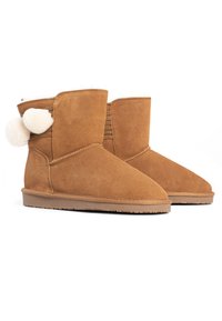 Botas de tobillo de ante color marrón con punta redonda, forro suave y detalle de pom-pom en la parte trasera. Presenta paneles laterales texturizados y una suela de goma plana.
