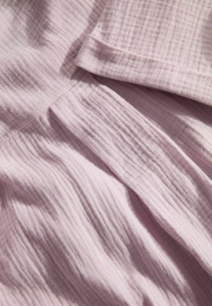 Lichtroze stof, met een zachte, gewrinklede textuur. Bevat subtiele strepen en een omgevouwen rand. Ideaal voor kleding of huishoudtextiel.