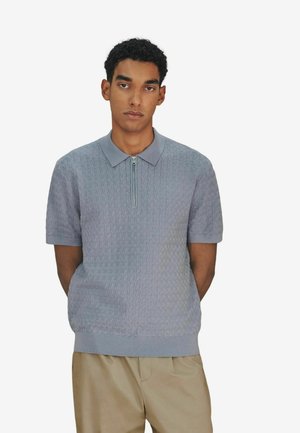 Kurzärmeliges Poloshirt in Hellgrau mit strukturiertem Muster, Kragen und einem halblangen Reißverschluss vorne. Weicher Stoff mit entspanntem Schnitt.
