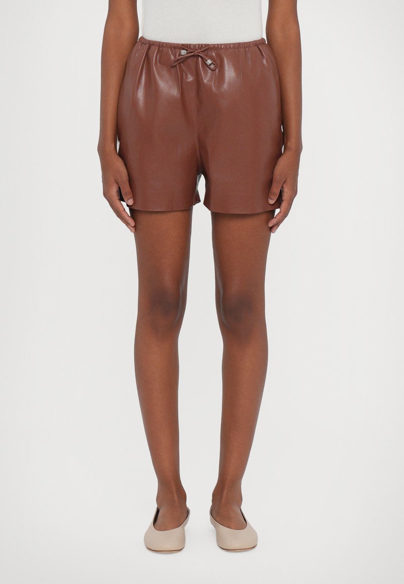 Brune faux læder shorts med elastisk talje og snoretræk, der har en glat tekstur og en afslappet, kort kant.