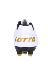 Valkoiset jalkapallosukkapohjat mustalla pohjalla ja keltaisilla napeilla. Takana on suuri kultainen "LOTTO"-logo. Sileä pinta ja virtaviivainen muotoilu.
