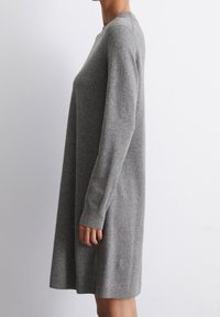 Abito a maglia grigio con maniche lunghe e scollatura a girocollo, caratterizzato da una silhouette ampia e orli e polsini a coste. Texture morbida.