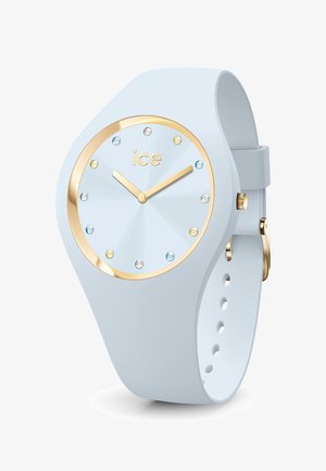 Helles blaues Silikonarmband mit einem runden Zifferblatt, goldenen Akzenten, kristallenen Markierungen und einem glatten, strukturierten Zifferblatt. Goldene Stunden- und Minutenzeiger.