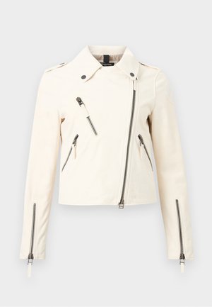 Chaqueta off-white asimétrica con cremallera, cuello, cuatro bolsillos visibles con cremallera y mangas largas con puños de cremallera.