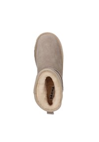 Bottine en suède beige avec une doublure en fourrure douce de couleur claire, bout arrondi et petit talon, dotée d'une languette à l'arrière.