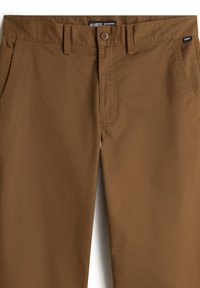 Braune Chinos aus glattem Stoff, mit Knopfverschluss, Gürtelschlaufen und normalen Taschen. Feine Steppnähte sind sichtbar.