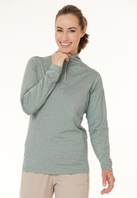 Lys grøn, langærmet pullover med kvart-zip krave. Har et glat stof og teksturerede sidelapper for åndbarhed.