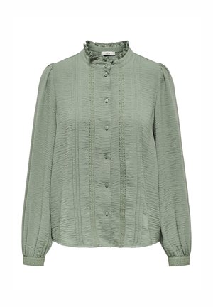 Košilová halenka v barvě šalvějové zeleně s dlouhými rukávy, volánkovým vysokým límcem, knoflíky vpředu, texturovanou látkou a krajkovými detaily na přední straně a manžetách.