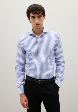 Camisa de vestir a rayas azul claro y blanca con mangas largas, cuello con botones y botones blancos, combinada con pantalones negros y un cinturón.