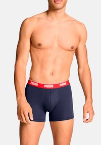 Boxer shorts de color marino con una amplia cinturilla roja que lleva el logotipo de Puma. Fabricados en algodón con una textura suave y un diseño ajustado.