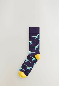 Chaussettes marine avec un motif de dinosaures bleu clair ; accents jaunes au niveau des orteils et des bords ; matériau doux au toucher lisse.