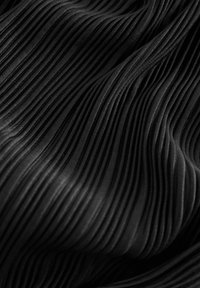 Tela negra plisada con finas rayas verticales, que presenta una textura suave y un patrón consistente en toda su extensión.