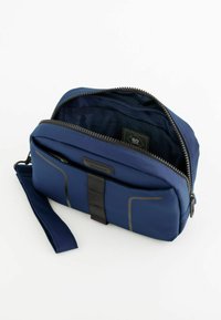 Marinblå reseväska, tillverkad av hållbart material, med dragkedjestängning, framficka och ett tyginsida med geometriskt mönster.