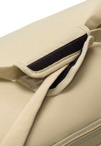Beige tas van textuurstof, voorzien van een rits en een klittenbandsluiting. Het ontwerp omvat externe en interne compartimenten.