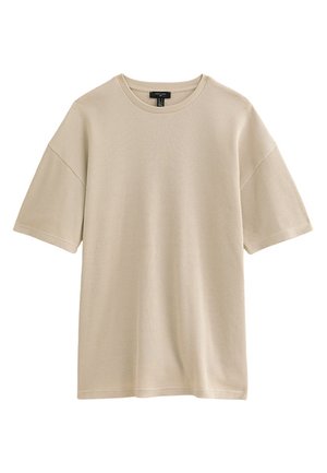 T-shirt à manches courtes en tricot côtelé beige avec un col rond et une coupe décontractée, présenté sur un fond blanc.