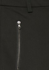 Čierne nohavice so bočnou zipsovou vreckom, vyrobené z hladkej tkaniny s elegantnou textúrou a minimalistickým dizajnom.