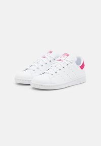 Vita lädersneakers med rosa detaljer vid hälen och tungan, rund tå, snörning och perforerade sidodetaljer.