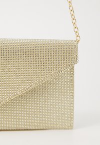 Gouden clutch tas bedekt met kleine, glanzende rhinestones, met een klepafsluiting en een kettinghengsel. Soepele textuur met een strakke rechthoekige vorm.