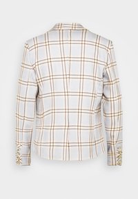 Blazer blanc avec motif à carreaux marron, manches longues et quatre boutons dorés sur chaque manche, vu de dos.