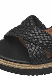Sandali in pelle intrecciata nera con design a incrocio, presentano una suola piatta e dettagli texture lungo il bordo.