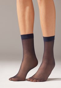 Calcetines tobilleros de red en color navy con un puño suave y texturizado. El material es ligero y ligeramente transparente, revelando la piel de debajo.