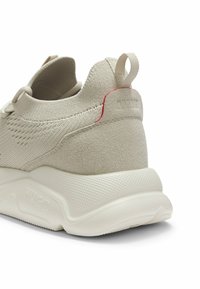 Talons de baskets en tricot beige avec surcouche en daim, languette de traction, semelle blanche texturée et logo "HUGO" embossé sur la semelle intermédiaire.