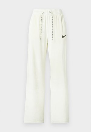 Bela Nike trenirka z elastičnim pasom, črnobele vrvice za zategovanje in črnih izvezenih Nike znak na levem stegnu.