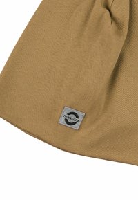 Beiger Strickstoff mit einer glatten Textur, der ein graues rechteckiges Etikett mit einem runden Logo und dem Markennamen "mikk-line" aufweist.