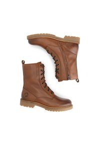 Bottines en cuir marron à bout rond, avec un laçage à l'avant, une fermeture éclair sur le côté et une semelle en caoutchouc texturé pour une meilleure adhérence. Logo de montagne sur le côté.