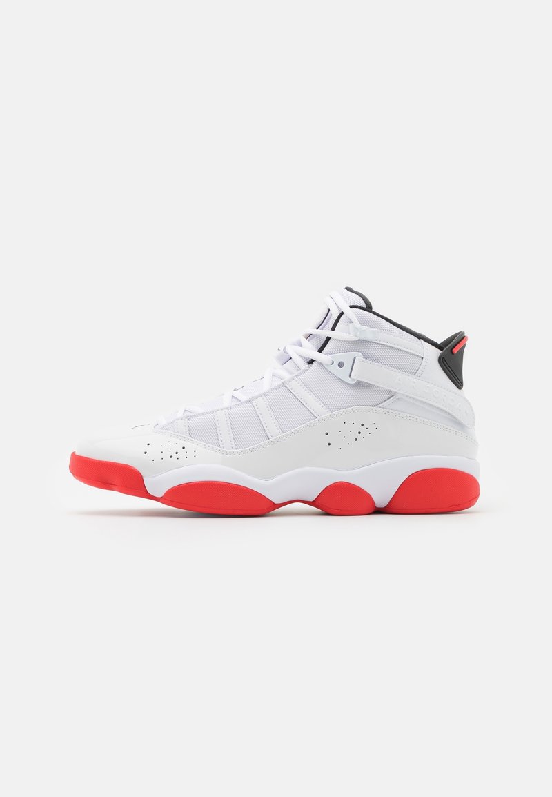 Chaussure de sport haute blanche avec semelle en caoutchouc rouge, panneaux en mesh et détails noirs sur le talon et la languette.
