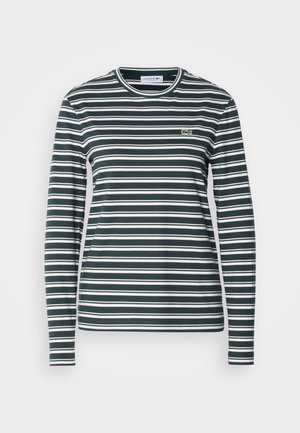 Ilga rankovė, apvalaus kaklo marškiniai su tamsiai žaliais ir baltais horizontaliais dryžiais. Papuošia mažas siuvinėtas logotipas ant krūtinės. Minkšta medžiaga.