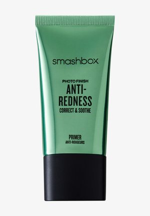 Tube vert Smashbox étiqueté "Photo Finish Anti-Rougeurs Correcteur & Apaisant Primer" avec un capuchon noir.