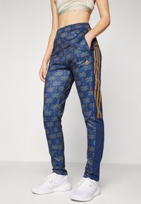 adidas Sportswear ADIDAS FARM RIO TIRO TRACK - Spodnji deli trenirk - bronze strata/dark marine/night indigo