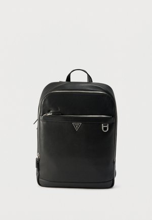 Fekete bőrből készült hátizsák ezüst cipzárokkal, elülső cipzáras zsebbel, fém Guess logóval és felső fogantyúval, egyszínű fehér háttéren.