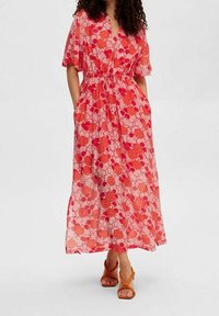 Blommig midiklänning i genomskinligt rosa tyg, med röda och orange blommönster, korta ärmar, elastisk midja och sidofickor.