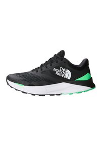 Scarpa sportiva nera con tomaia in mesh, intersuola bianca, dettagli verdi e suola in gomma testurizzata. Presenta il logo del marchio sul lato.