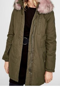 Parka verde oliva con cappuccio in pelliccia rosa rimovibile, dotata di chiusure a zip e a pressione, tasche laterali e vita con cintura.