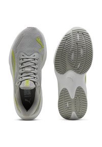 Zapatillas deportivas grises con parte superior de malla, acentos en color lima y cordones planos. Cuenta con una suela de goma texturizada con un patrón de tracción para un mejor agarre.