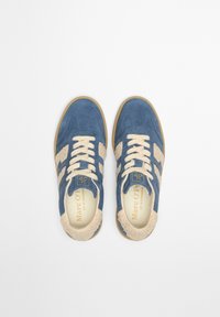 Niebieskie zamszowe sneakersy z kremowymi akcentami z futra, sznurowadłami i beżową gumową podeszwą. Oznaczone napisem "Marc O’Polo" wewnątrz. Klasyczny, casualowy design.