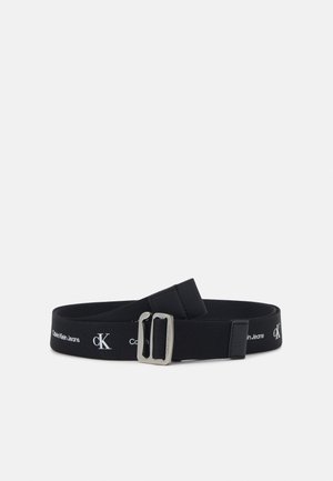 Czarny materiałowy pasek Calvin Klein z srebrną klamrą i białym logo powtarzającym się wzdłuż paska.