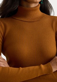 Rebrasti pulover s turtleneck ovratnikom v bogati oranžno-rjavi barvi, ki se ponaša z oprijetim krojem in dolgimi rokavi ter visokim ovratnikom.
