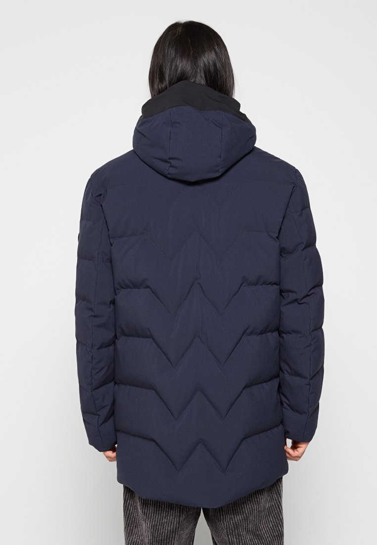 Marineblaue Daunenjacke mit Kapuze, ausgestattet mit einem Zickzack-Steppmuster, Reißverschluss und einer glatten, strukturierten Oberfläche.