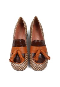 Brązowe, wzorzyste szpilki z błyszczącą czubkiem i skórzanymi akcentami w postaci frędzli. Wzór w zęby psa na zewnętrznej powierzchni.