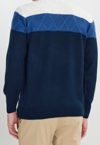 Marineblauer Pullover mit diamantförmigem Strickmuster am oberen Rücken; mit weißen und hellblauen Bereichen an den Schultern und mit Rippbündchen.