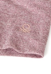 Produkt tekstylny w melanżowym odcieniu różu z miękką, dzianą fakturą; posiada wypukłe logo w jasnoróżowym kolorze.