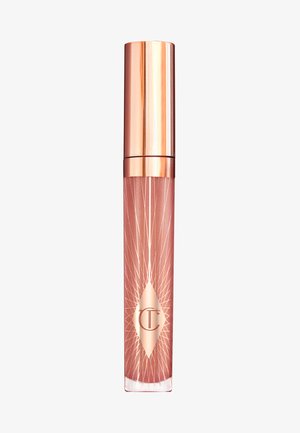 Gloss à lèvres dans un tube transparent rose avec un capuchon métallique rose doré. Présente un logo en diamant et un motif de rayons de soleil sur le côté.